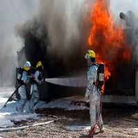 Airman gleda kako kolege vatrogasci žure za u borbi sa plakerom za plakat tisku Stocktreka slika